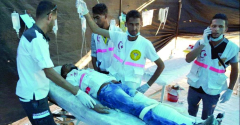 مسعفون يعالجون زميلهم المصاب (تويتر)