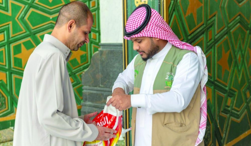 موظف يؤدي عمله بأحد أبواب المسجد الحرام (واس)