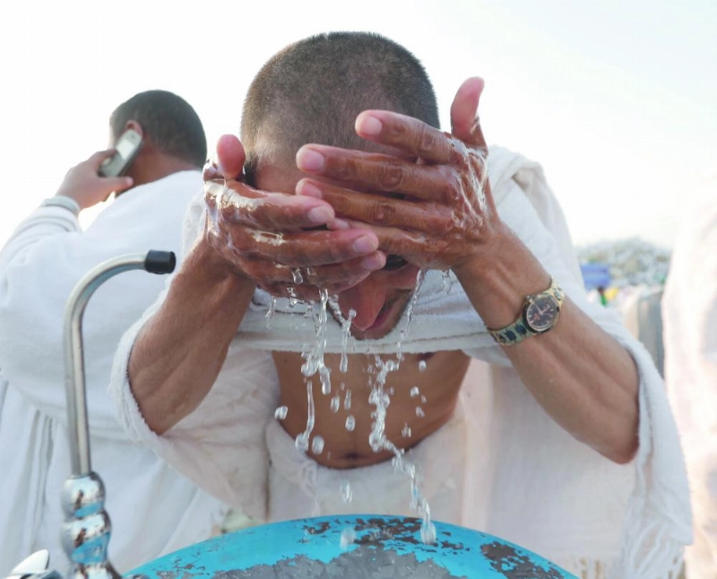 حاج يضع الماء على وجهه في عرفات (ياسر بخش)