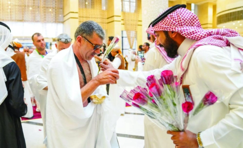 موظف يوزع الورود على حجاج البرنامج (مكة)