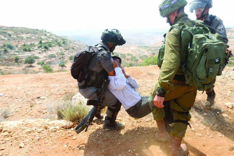 Israeli soldiers scuffle with a Palestinian protester during a protest against Jewish settlements in the village of Ras Karkar, near the West Bank city of Ramallah, 31 August 2018. Photo: Shadi Hatem/APA Images via ZUMA Wire/dpa