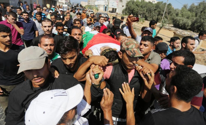 فلسطينيون يحملون جثة شاب قتل خلال اشتباكات مع قوات الاحتلال (د ب أ)