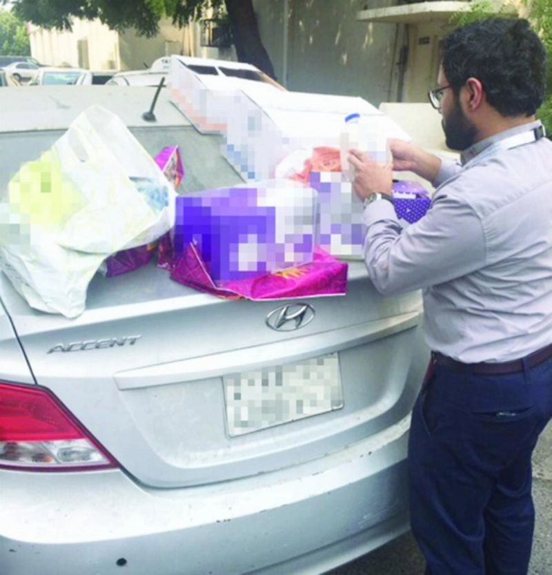 موظف يعاين منتجات ضبطت بحوزة أحد المسوقين (مكة)