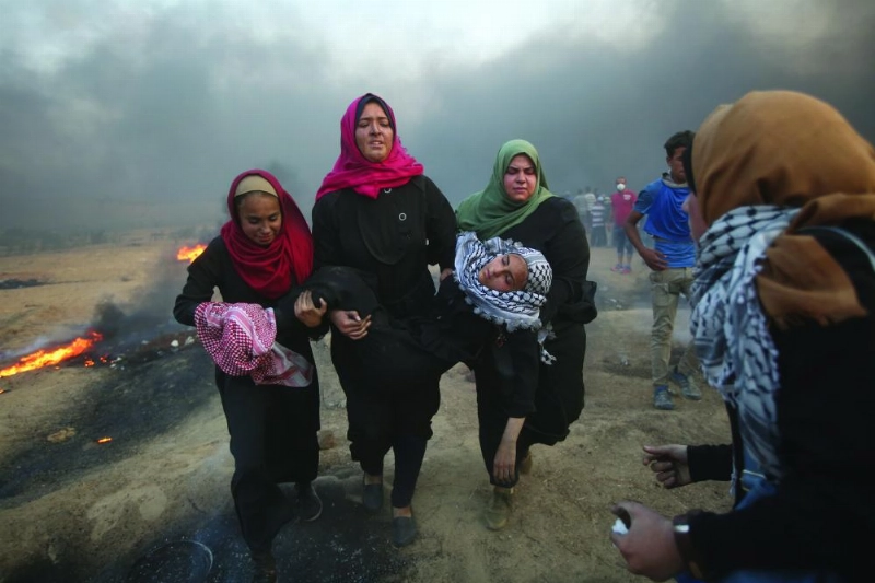 فلسطينيات خلال إجلاء متظاهرات مصابات (د ب أ)