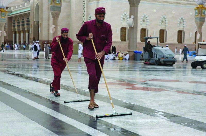 عمال يباشرون نظافة ساحات المسجد النبوي بعد هطول الأمطار (واس)