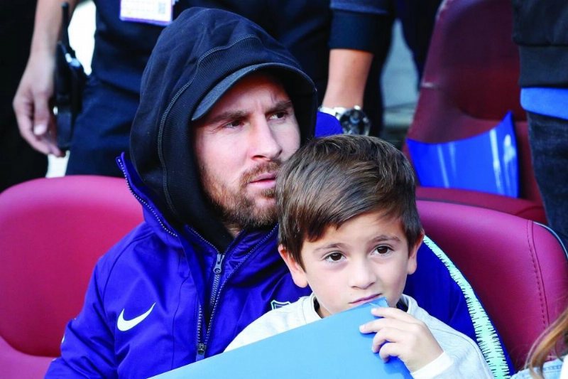 ميسي وابنه خلال مباراة برشلونة وريال مدريد (د ب أ)