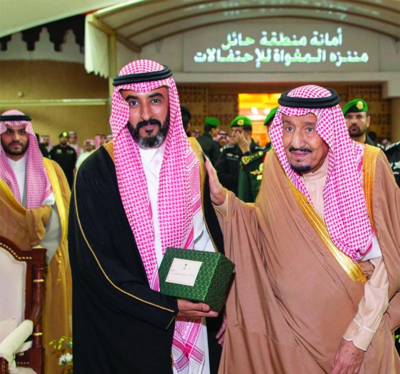 الملك سلمان لدى تكريمه أحد المميزين في حائل