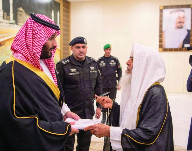 ولي العهد مصافحا أسر الشهداء في تبوك