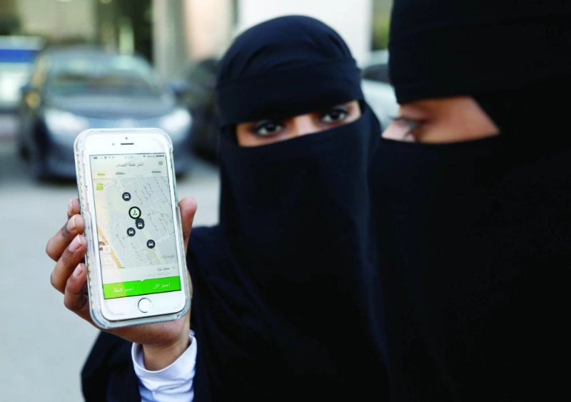 سيدتان أثناء استخدامهما تطبيق المركبات الموجه (مكة)