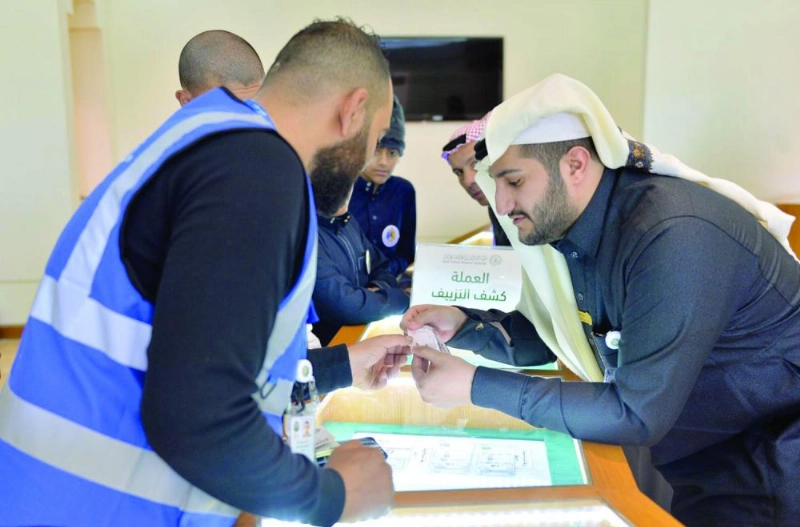 زوار يتعرفون على فحص الأوراق النقدية (واس)