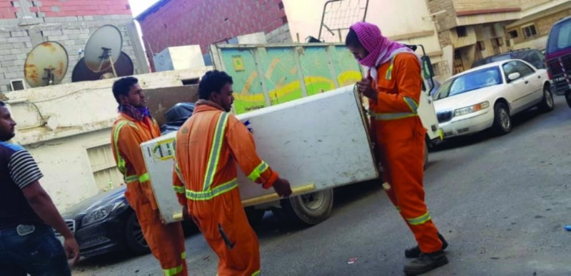 عمال نظاقة يرتبون الأثاث بمنزل المسن