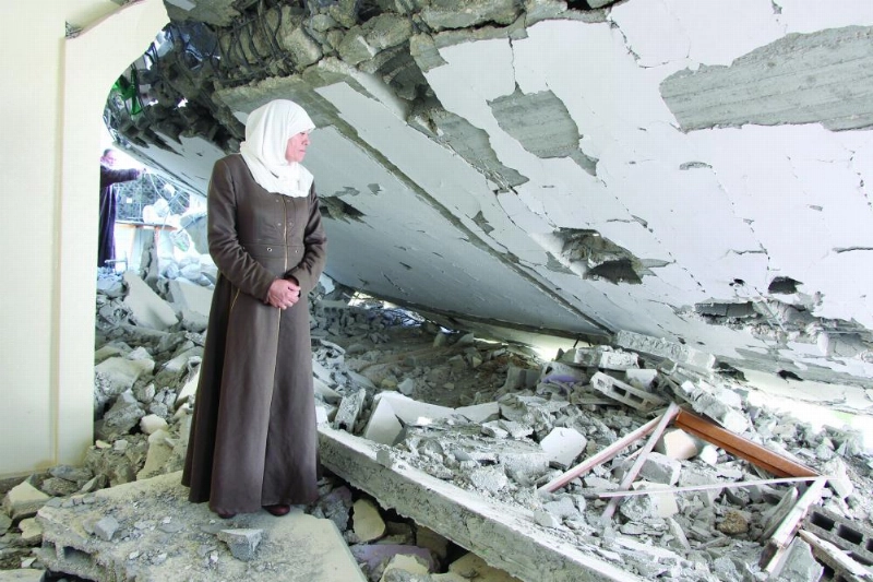 امرأة فلسطينية تقف على بقايا منزل هدمته القوات الإسرائيلية (د ب أ)