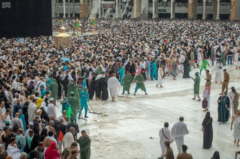 العاملين في المسجد الحرام خلال عملية نظافة صحن المطاف من الأمطار ( مكة )
