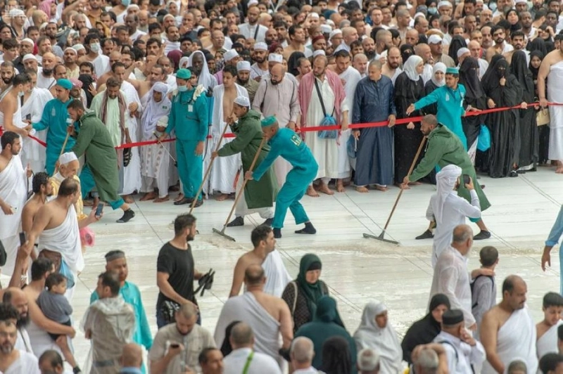 العاملين في المسجد الحرام خلال عملية نظافة صحن المطاف من الأمطار ( مكة )