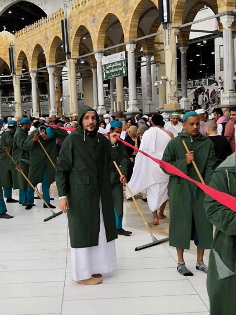 عمال أثناء إزالة مياه الأمطار بالمسجد الحرام (واس)
