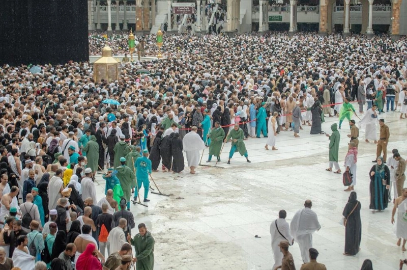 عمال أثناء إزالة مياه الأمطار بالمسجد الحرام (واس)