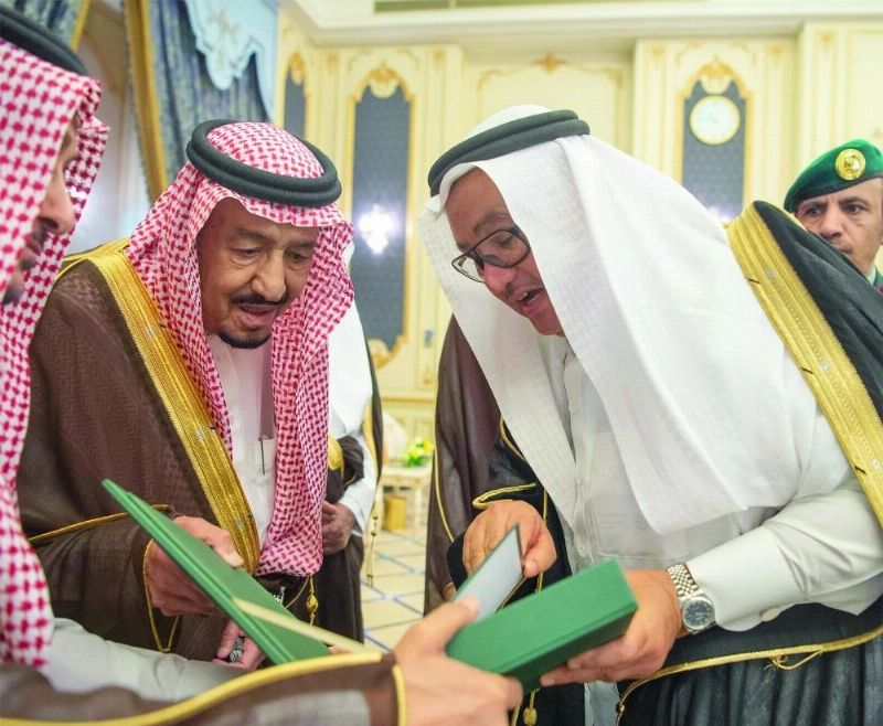 خادم الحرمين مطلعا على أحد التقارير خلال الاستقبال (واس)