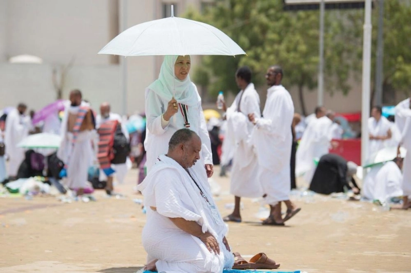 حاجة تظلل زوجها أثناء أدائه الصلاة