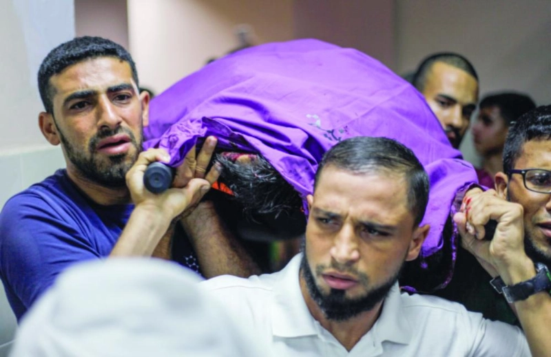 فلسطينيون يحملون جثمان أحد القتلى (د ب أ)