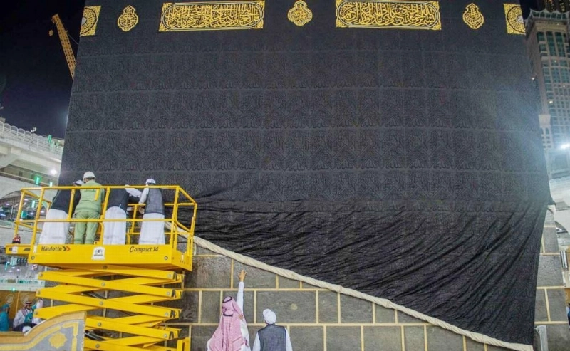 من إسدال ثوب الكعبة وتثبيته بحلقات الشاذروان المذهبة (مكة)
