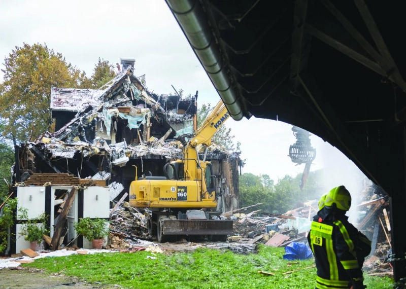 18 September 2019, North Rhine-Westphalia, Muenster: An excavator demolishes a half-timbered house after it caught on fire following an explosion in the building. Two women and a policeman were injured. Photo: Bernd Thissen/dpa