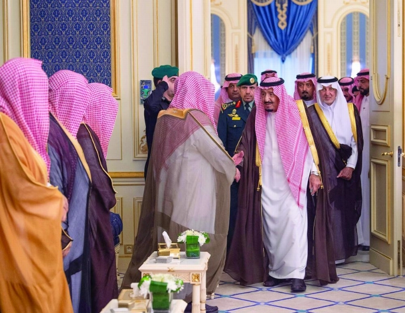 الملك سلمان خلال استقباله الأمراء والعلماء وجمعا من المواطنين أمس (واس)