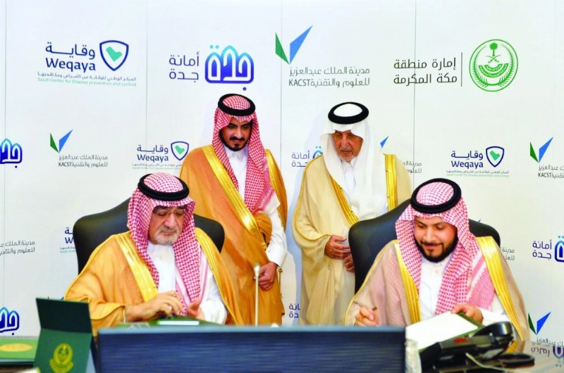 خالد الفيصل وبدر بن سلطان خلال توقيع الاتفاقيتين (مكة)