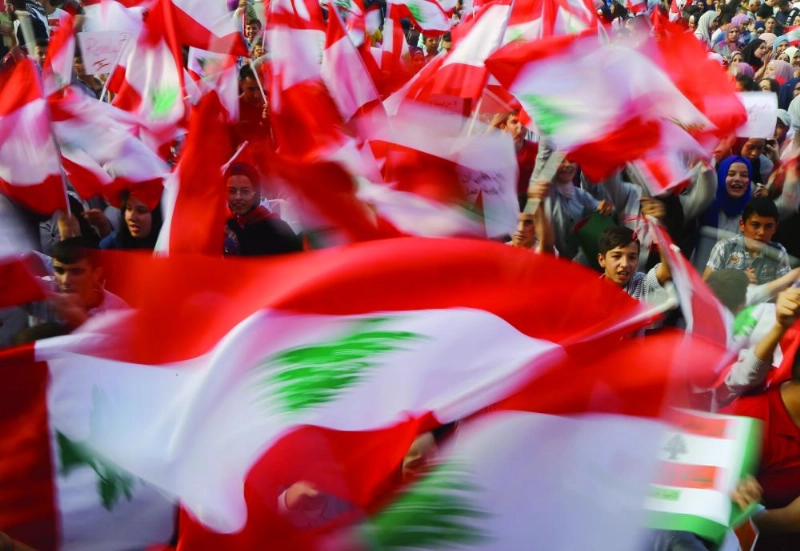 لبنانيون يلوحون بأعلامهم في المظاهرات (د ب أ)