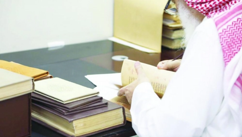 قارئ يطلع على أحد الكتب بمكتبة عامة (مكة)
