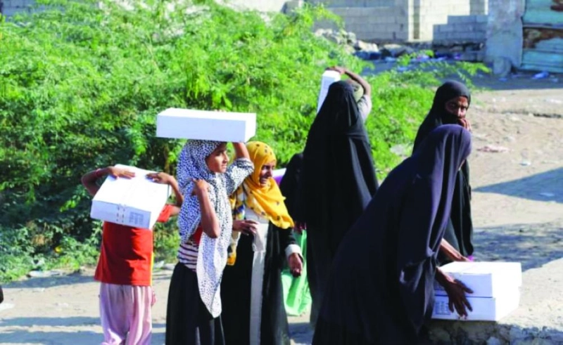 نساء وأطفال يحملون كراتين تمر سعودي (واس)