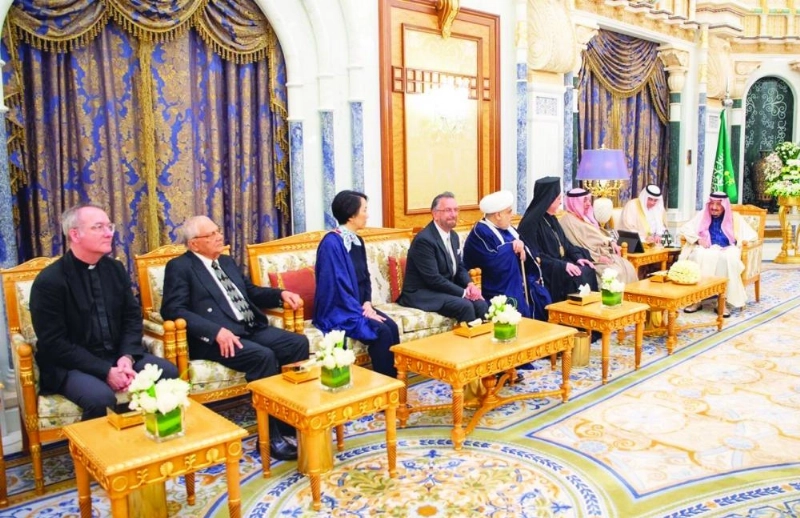 الملك سلمان لدى استقباله أمين وأعضاء مركز الملك عبدالله العالمي للحوار بين أتباع الأديان أمس (واس)