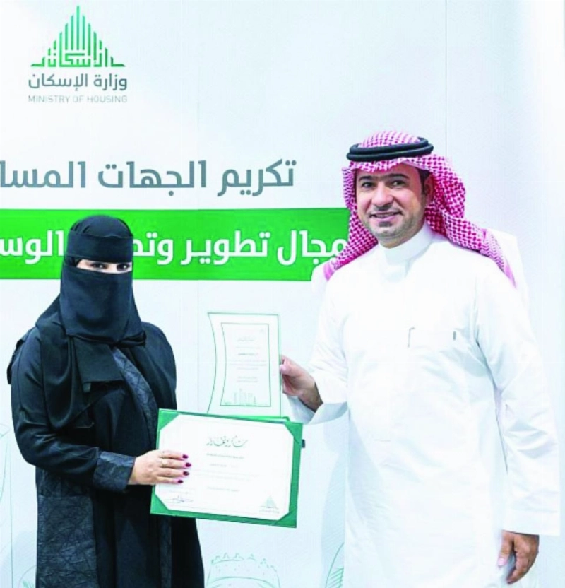 الحقيل أثناء تكريم إحدى المستفيدات (الإسكان)