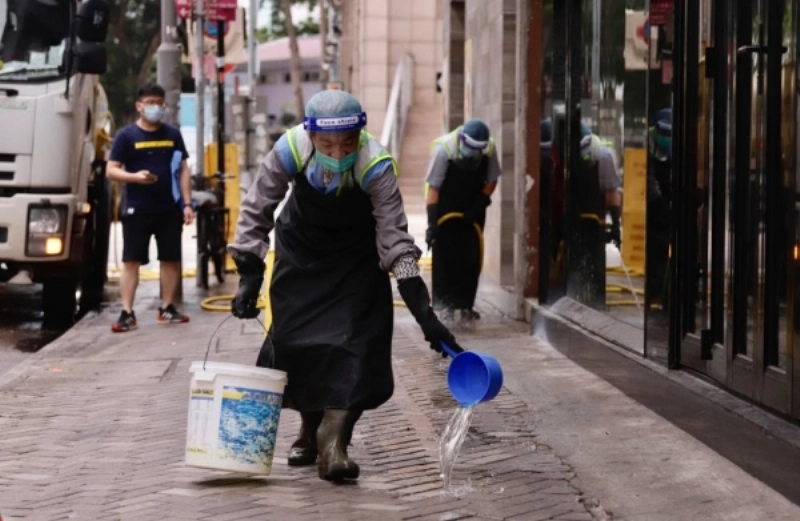 عاملة نظافة في هونج كونج تطهر الشارع (د ب أ)