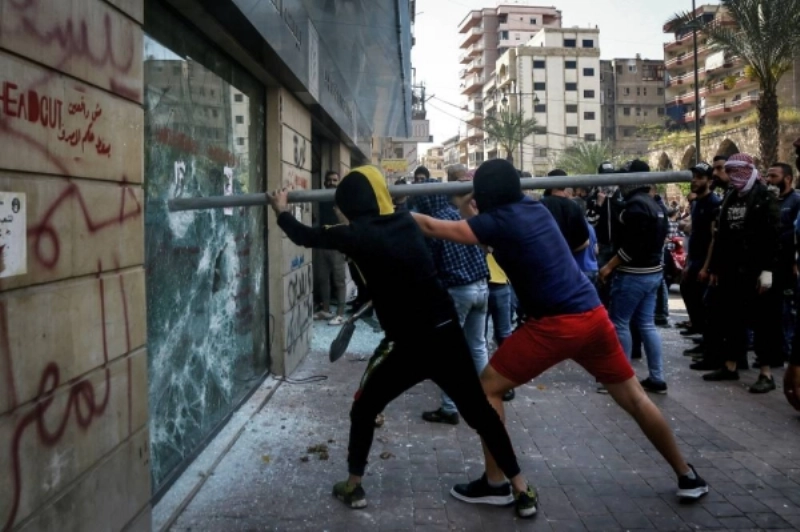 محتجون لبنانيون يحاولون اقتحام أحد المحال (د ب أ)