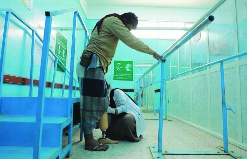 شاب يمني يتأكد من أحد الأقدام الصناعية (واس)