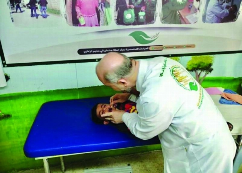 أحد أفراد الفريق الطبي يكشف على طفل (واس)