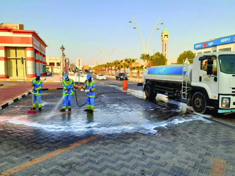 عمال البلدية خلال غسل وتعقيم الأرصفة (مكة)