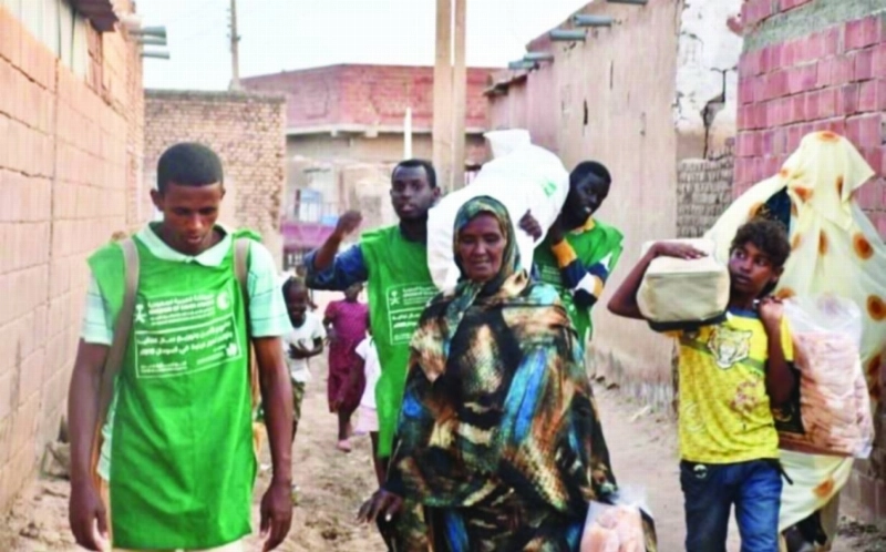 سودانيون يحملون المواد الإيوائية السعودية (واس)