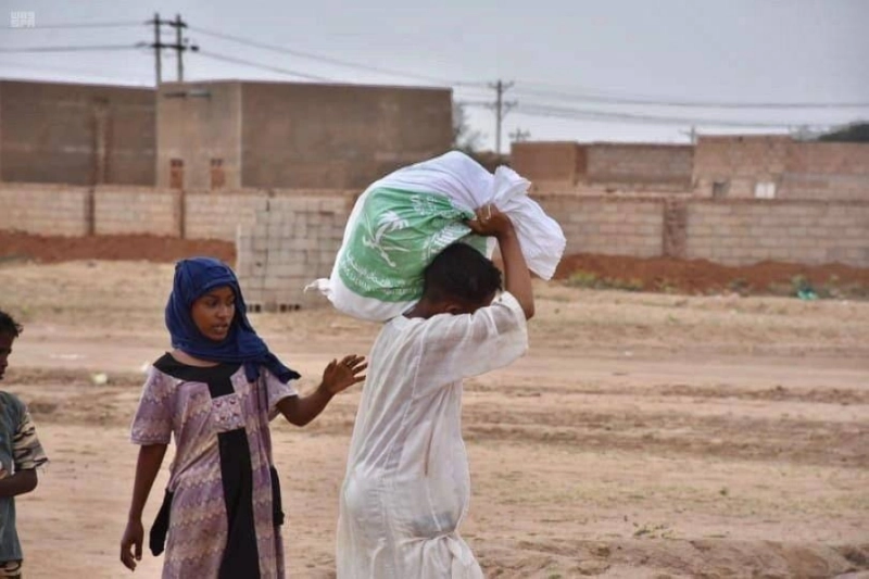 سوداني يحمل سلة مركز الملك سلمان للإغاثة (واس)