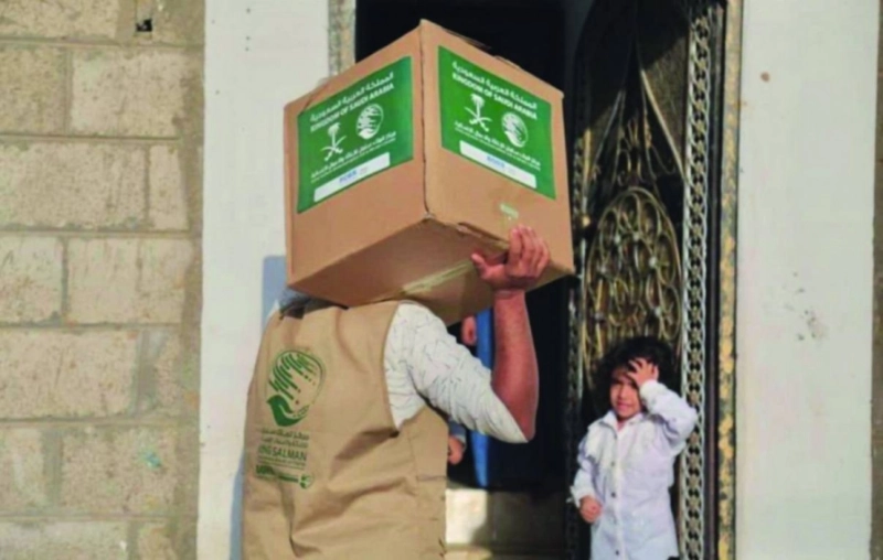 متطوع يصل بالحقائب إلى أحد المنازل (واس)