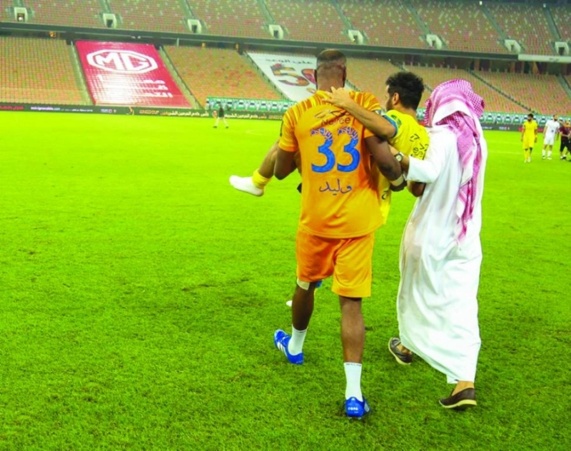 وليد عبدالله والحلافي يحملان عبدالفتاح عسيري (ياسر بخش)