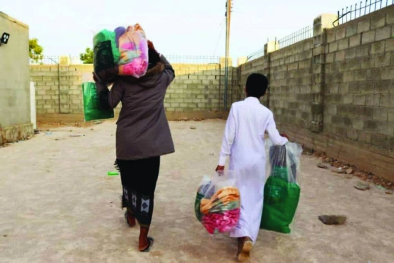 يمنيان يحملان حقائب مركز الملك سلمان للإغاثة