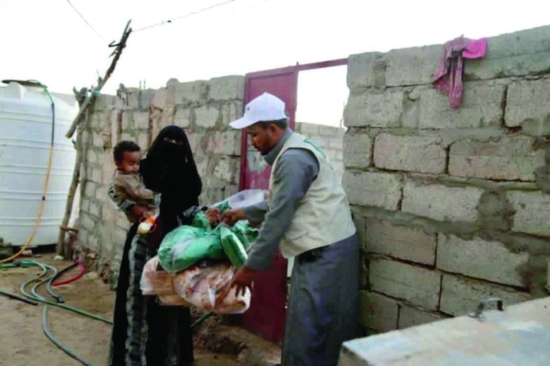 متطوع يسلم يمنية الحقيبة الشتوية (واس)