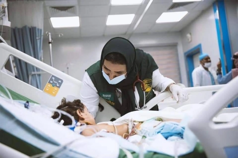 طبيبة من مركز الملك سلمان تداعب طفلة مريضة باليمن (واس)