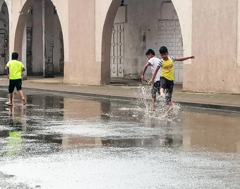 أطفال فرحون بهطول الأمطار على مكة (أنس الحارثي)
