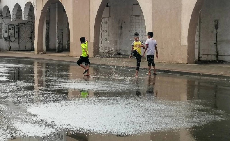 أطفال فرحون بهطول المطر في مكة الخميس الماضي (أنس الحارثي)