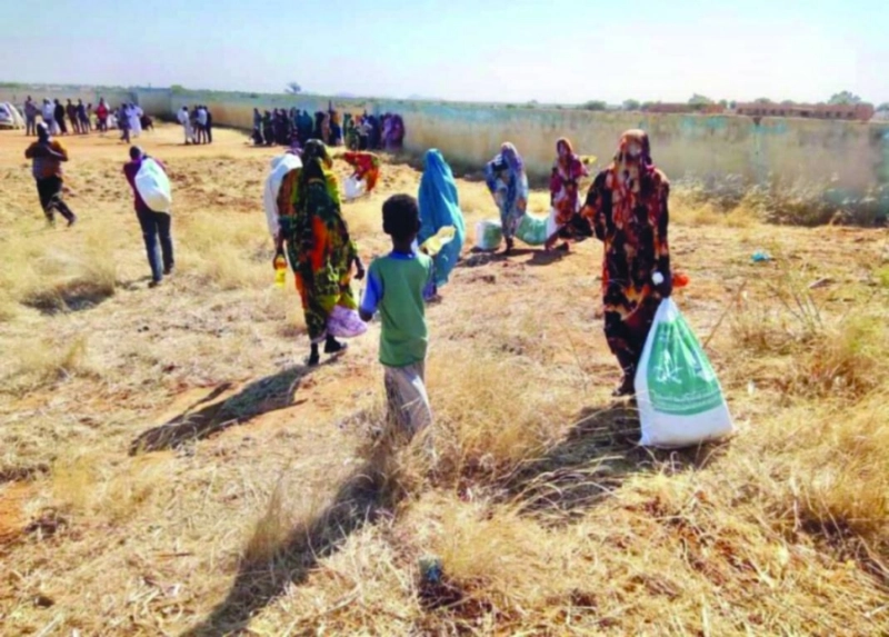 سودانيات يحملن مواد غذائية من مركز الملك سلمان (واس)