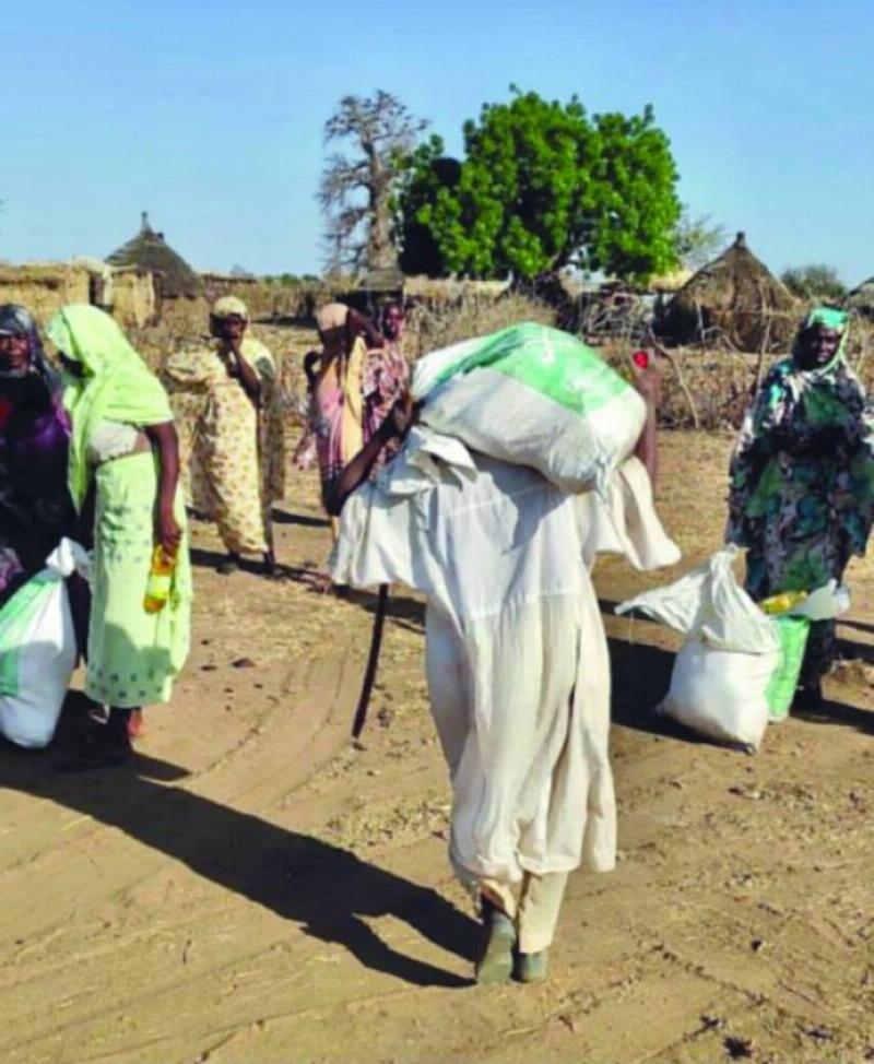 سوداني يحمل مواد سلمها مركز الملك سلمان للإغاثة (واس)