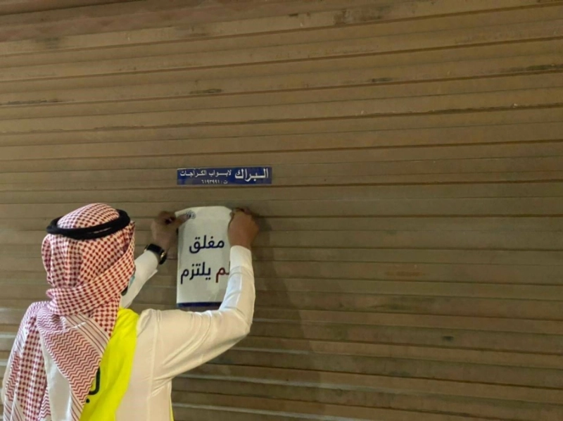 مراقب البلدية يغلق أحد المحال المخالفة (مكة)