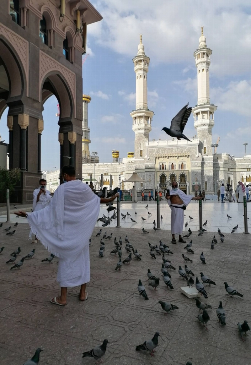 حرص المعتمرون في أول أيام رمضان على إطعام الحمام والتقاط الصور التذكارية (أنس الحارثي)